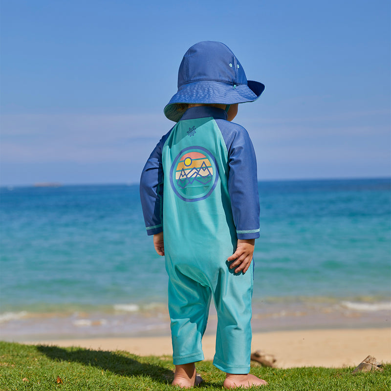 Baby boy on the beach in UV Skinz's baby boy's long-sleeve swimsuit in endless summer|endless-summer