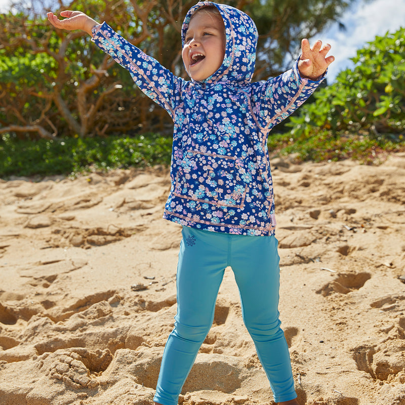 Little girl dancing on the beach in UV Skinz's swim tights in lagoon|lagoon