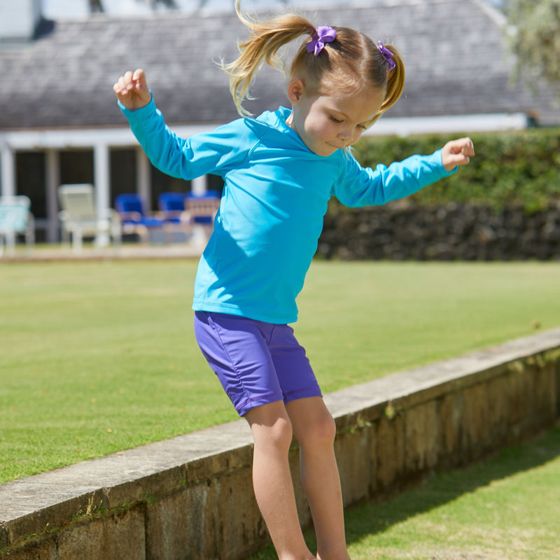 Little girl playing in UV Skinz's purple swim shorts|purple