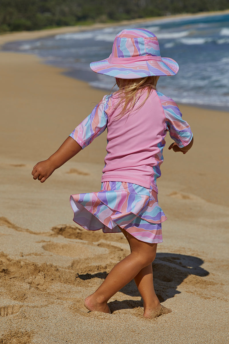 Little girl in UV Skinz's girl's swim hat in rollin along|oops-a-daisy