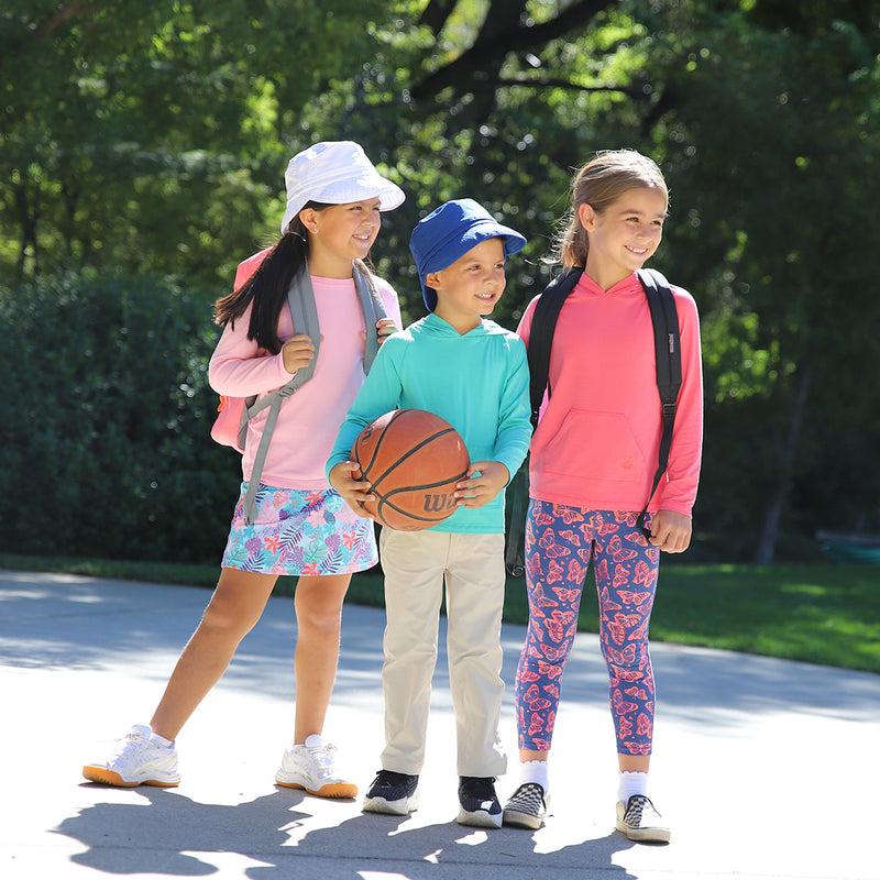 Boy playing with friends in UV Skinz's boy's fairway pants in stone|stone