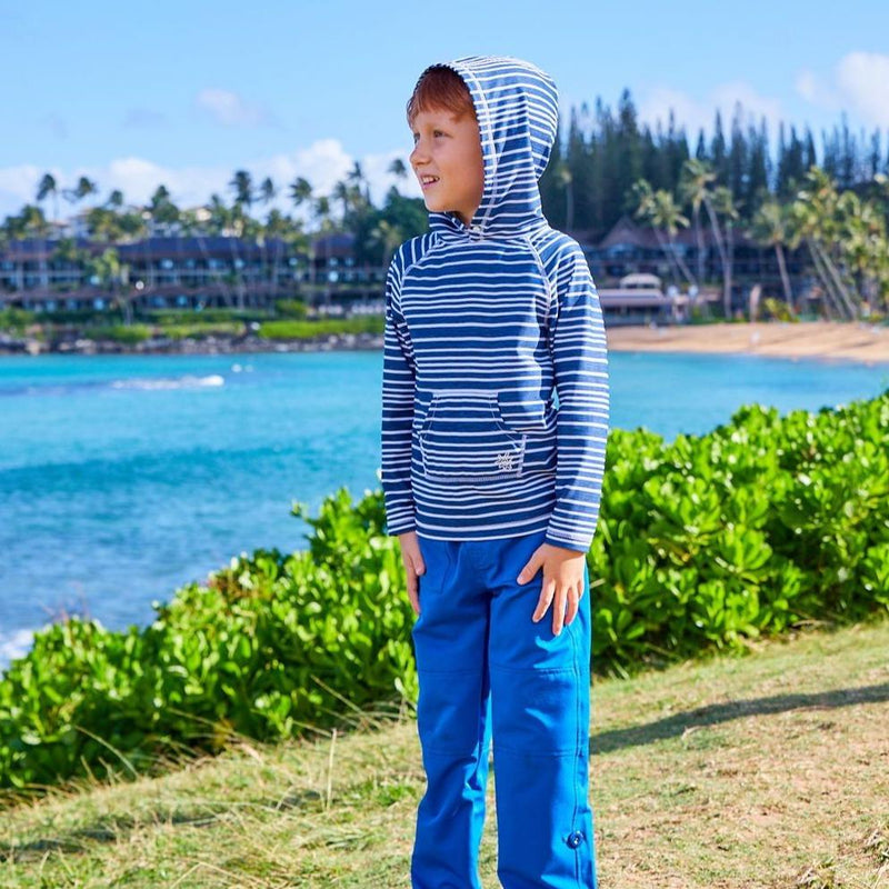 Young boy at a resort in UV Skinz's boy's pullover hoodie looking at the ocean|electric-green-stripe