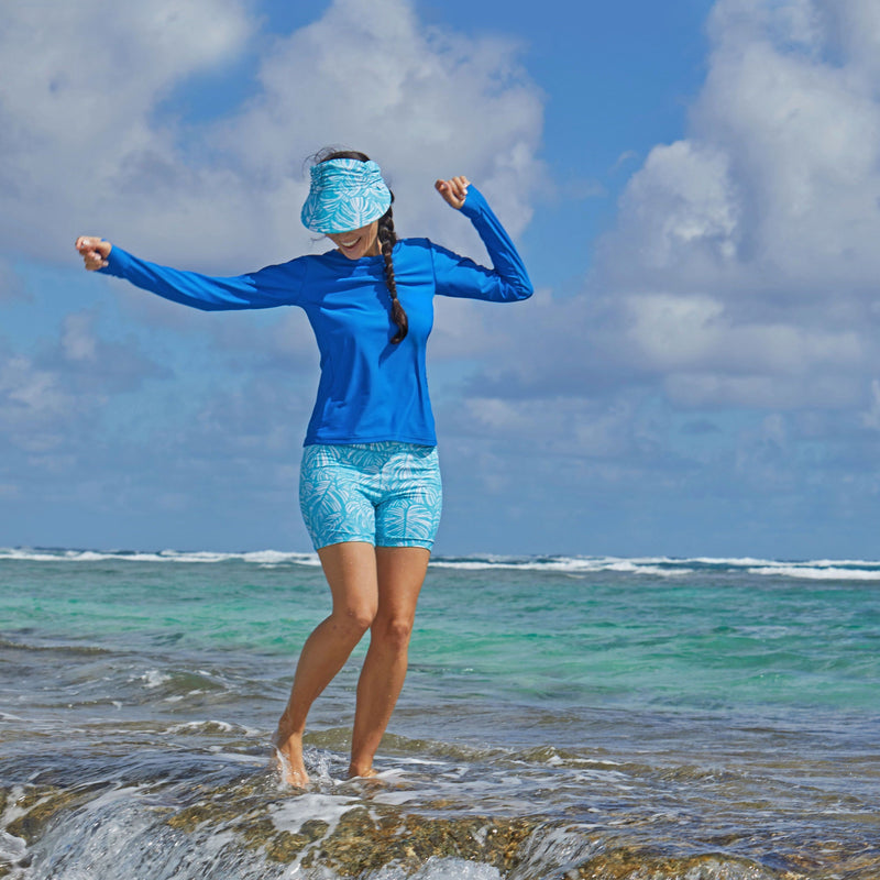 Woman in UV Skinz's women's long sleeve crew swim shirt in scuba blue|scuba-blue