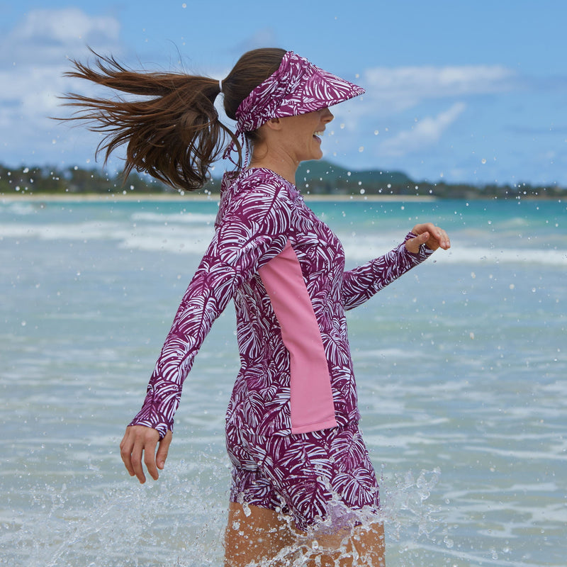 Woman in UV Skinz's women's long sleeve swim shirt with UPF in wine botanical|wine-botanical