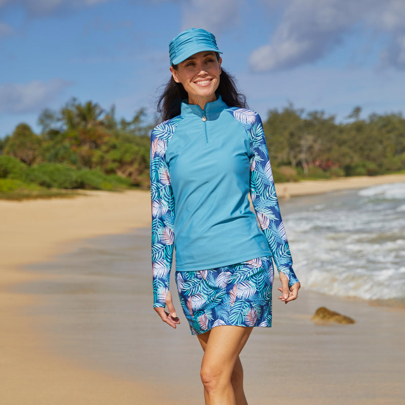 Woman wearing UV Skinz's women’s long sleeve quarter zip swim shirt in koa leaves|koa-leaves