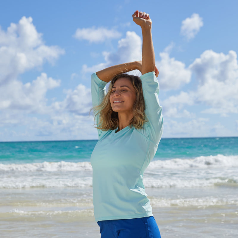 Woman Enjoying the Sun in UV Skinz's Women's V-Neck Sun & Swim Shirt in Beach Glass|beach-glass