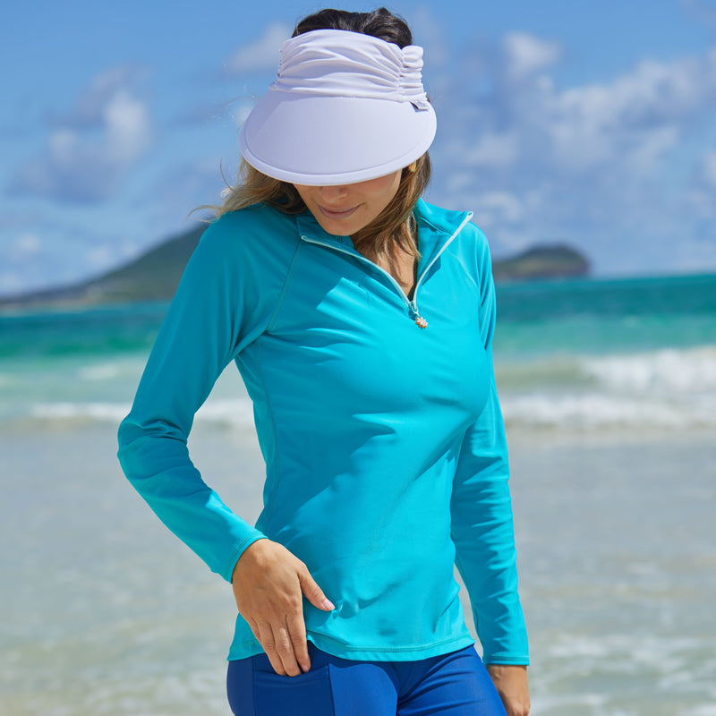 Woman wearing UV Skinz's women’s long sleeve quarter zip swim shirt in teal|teal