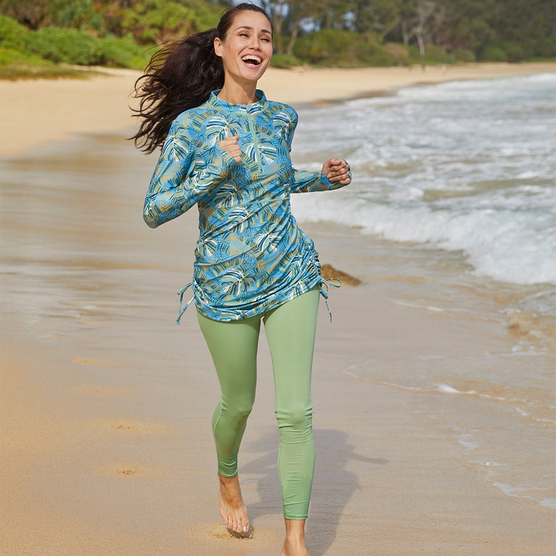 woman running on the beach in UV Skinz's convertible swim/shirt dress|tahoe-tropical