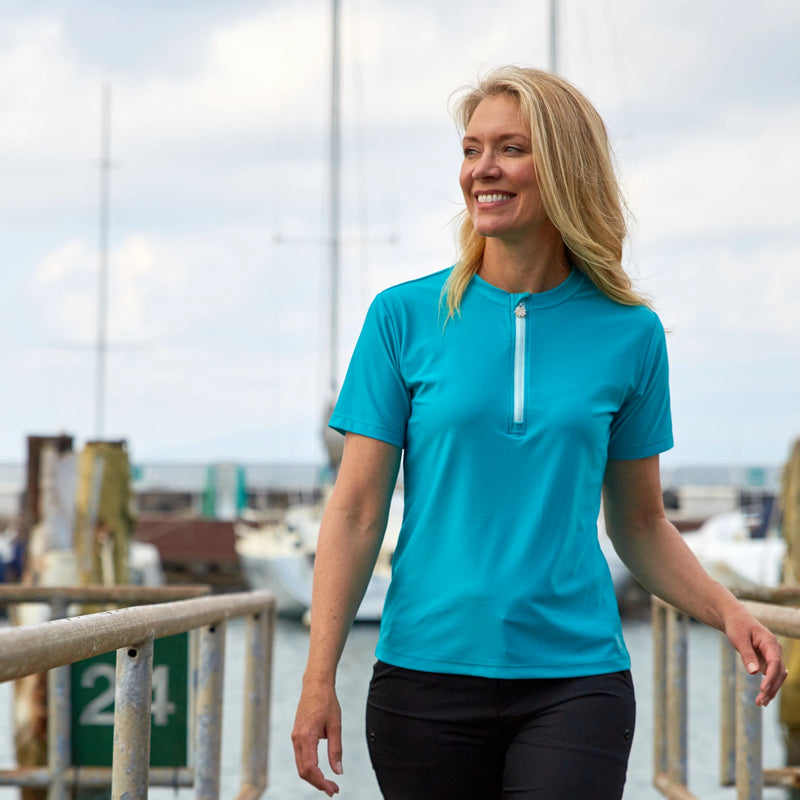 Woman walking on the docks in UV Skinz's women's quarter zip crew swim shirt|charcoal