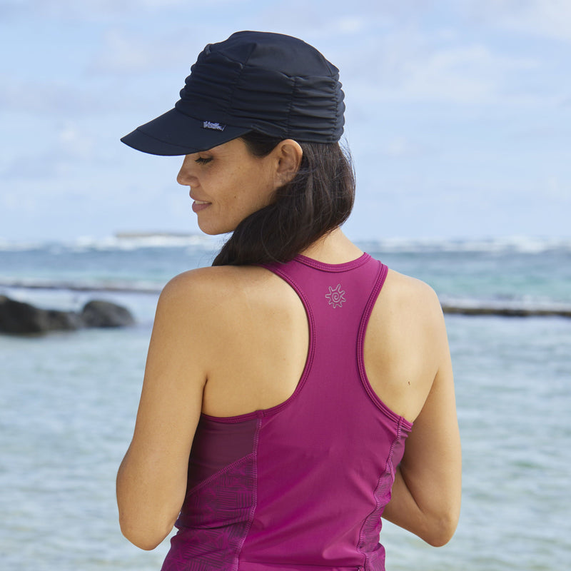 Woman wearing UV Skinz's women's swim cap in black|black