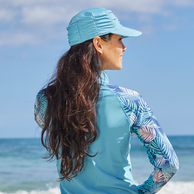 Woman wearing UV Skinz's women's swim cap in lagoon|lagoon