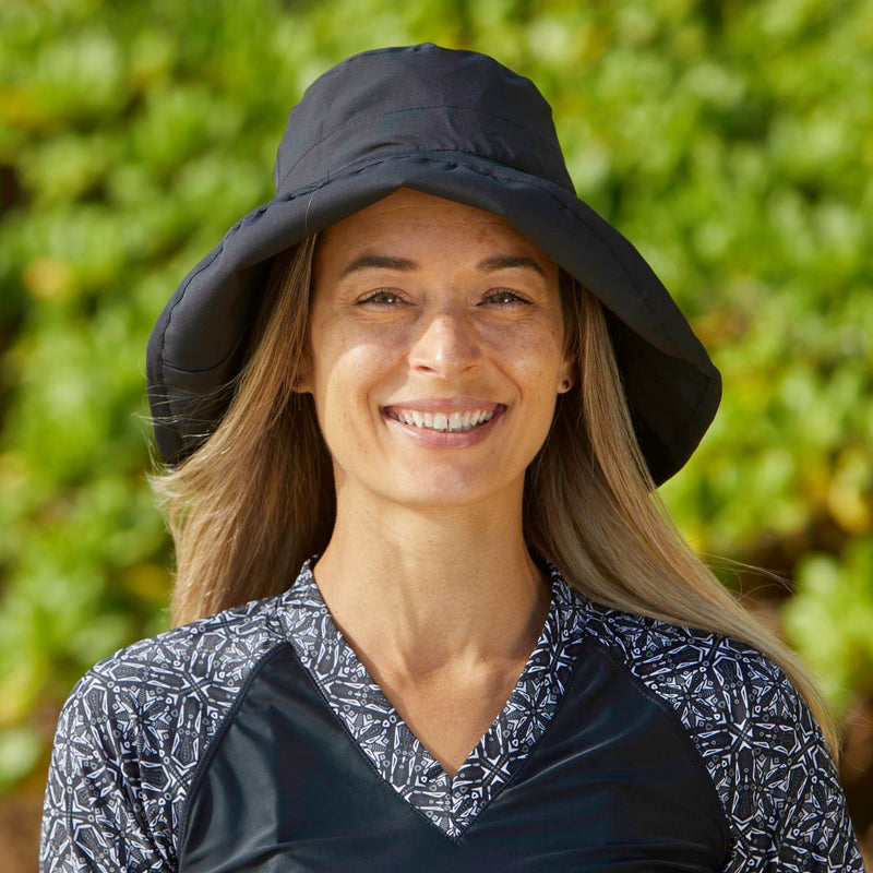 Woman in UV Skinz's Women's Rolled Brim Hat|black