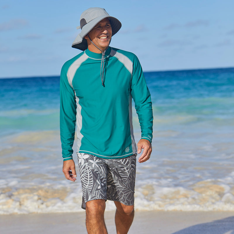 Man on the beach in UV Skinz's board shorts|charcoal-oasis