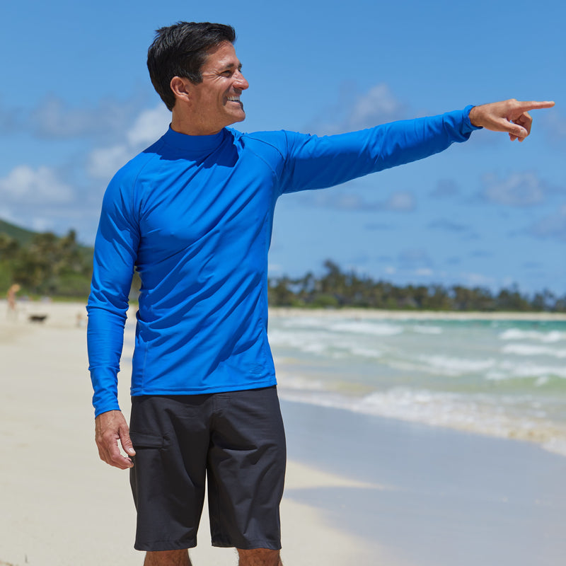 Man on the beach in UV Skinz's men's long sleeve active swim shirt in deep sea|deep-sea