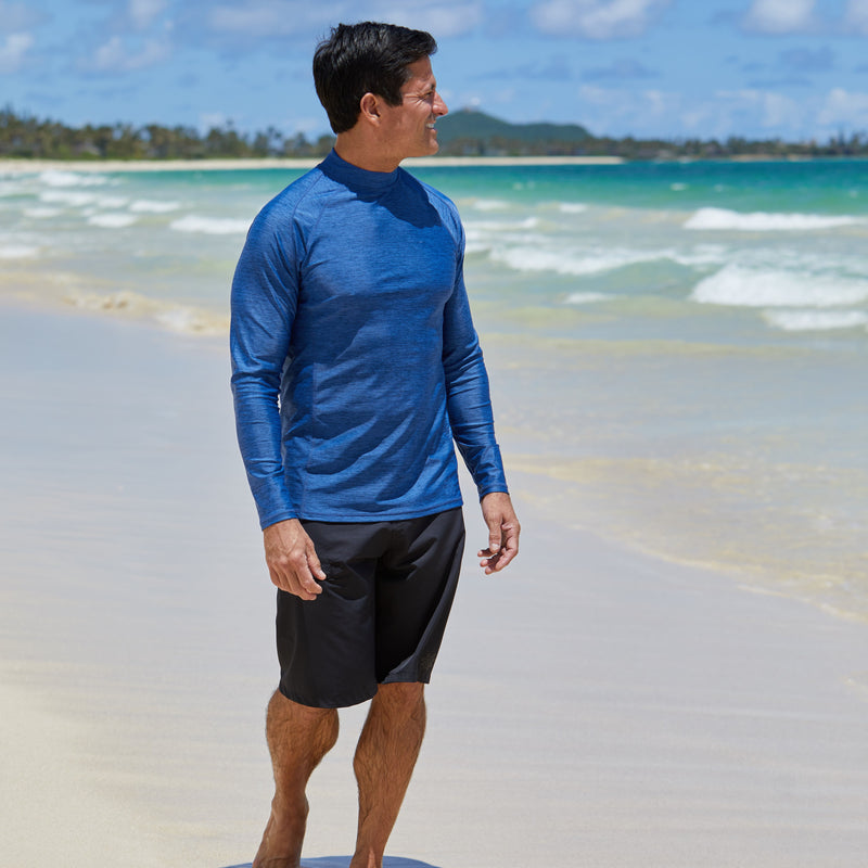 Man on the beach in UV Skinz's men's long sleeve active swim shirt|washed-navy-jaspe