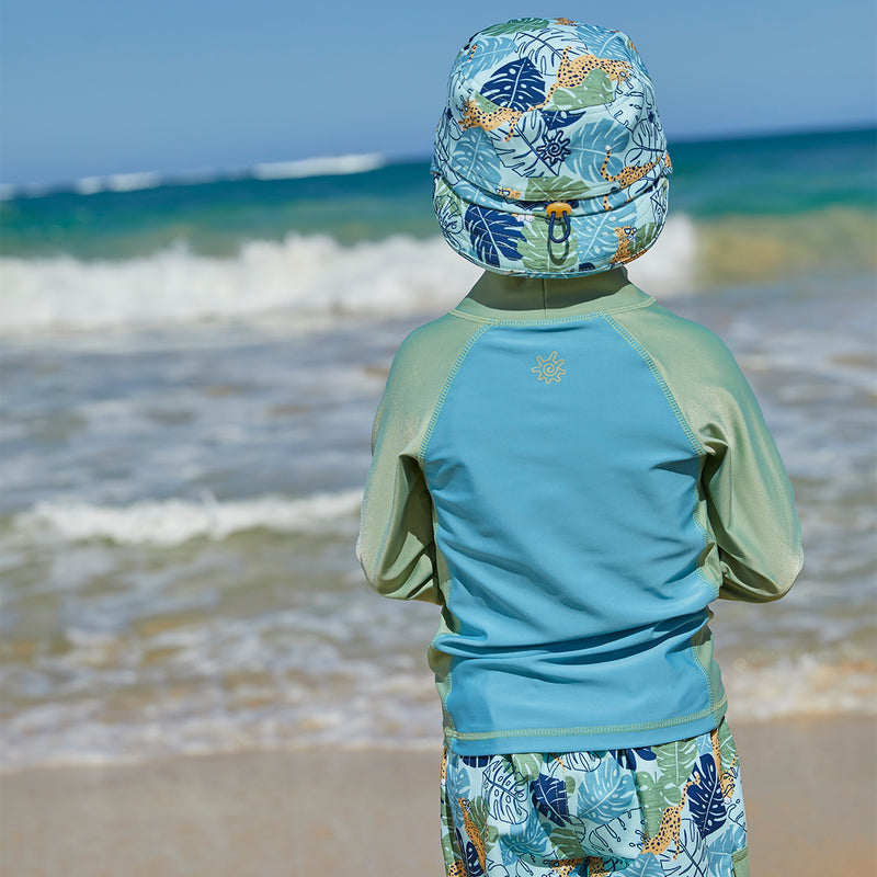 Back of a boy wearing UV Skinz's kid's adjustable flap sun hat|stained-glass