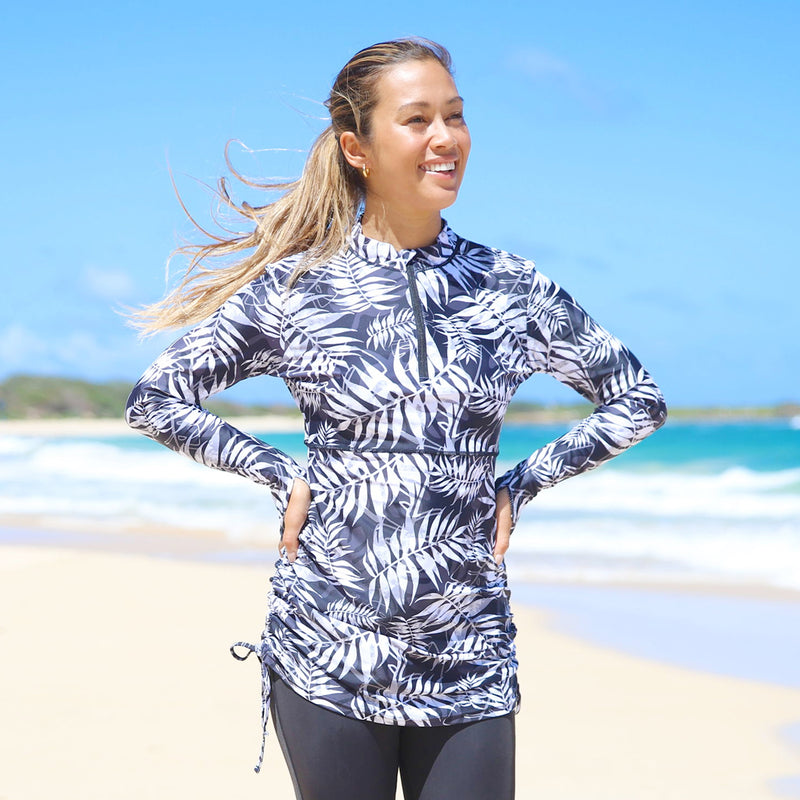 woman on the beach in UV Skinz's swim dress/shirt in black palms|black-palms