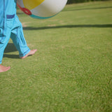 Baby boy playing in UV Skinz's long-sleeve swimsuit with UPF