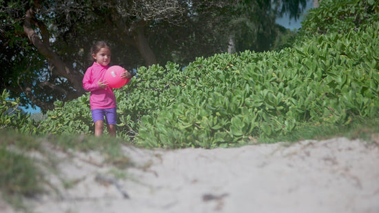 Girl playing in UV Skinz's girl's swim shorts