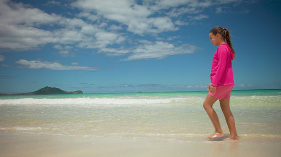 Girl on the beach in UV Skinz's girls pullover hoodie 