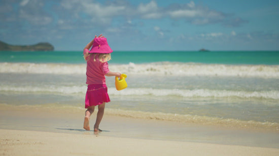 Little Girl Playing in the Ocean in UV Skinz's Girls Bucket Hat