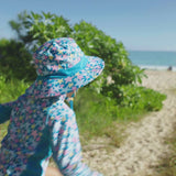 Little girl playing on the beach wearing UV Skinz's girl's swim hat