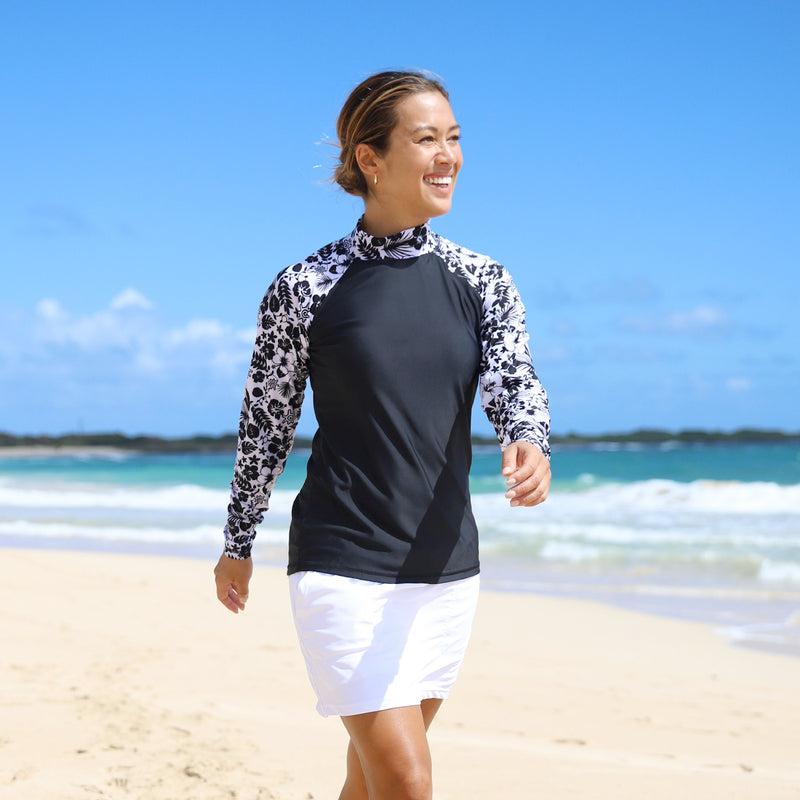 Woman Walking Down the Beach Smiling in the Women's Aloha Long Sleeve Sun & Swim Shirt in Black Aloha|black-aloha