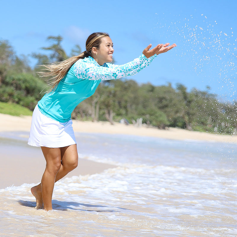 Asian Woman Splashing in the Ocean in the Women's Aloha Long Sleeve Sun & Swim Shirt in Teal Aloha|teal-aloha