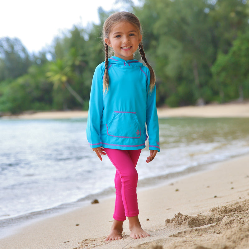 Little girl on the beach in UV Skinz's hot pink swim tights|hot-pink