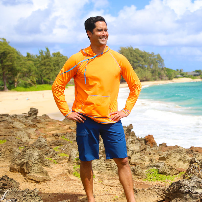 Man on the beach in UV Skinz's men's coastal board shorts in dark navy|dark-navy