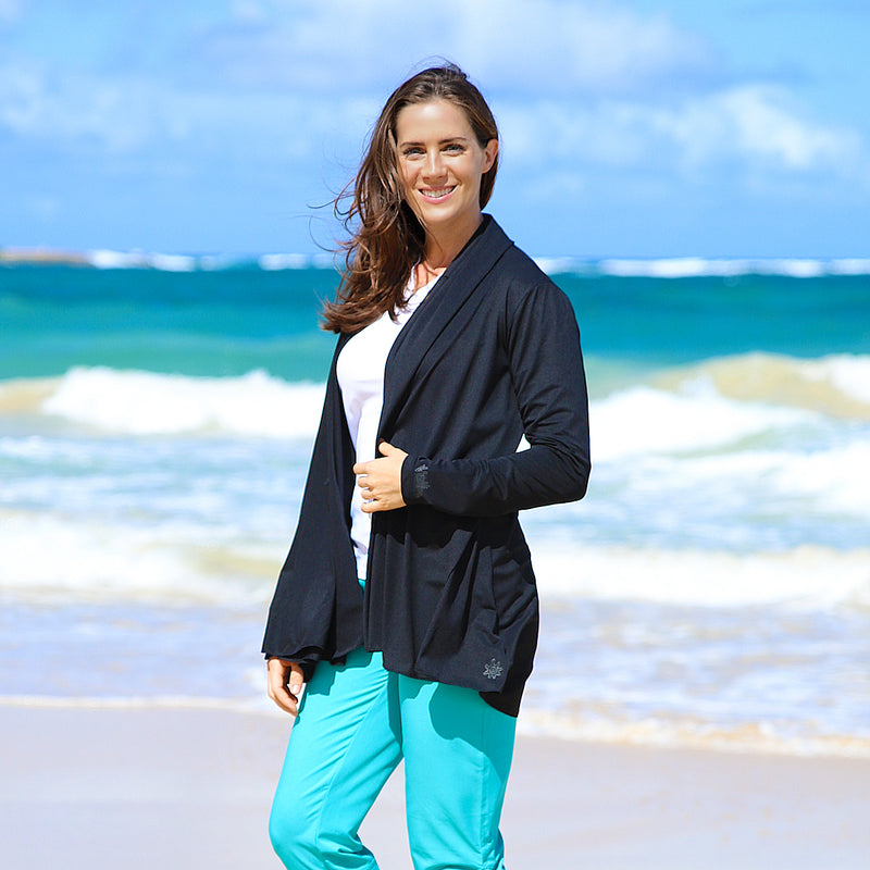 Woman in UV Skinz's women's hooded beach cover up in black|black