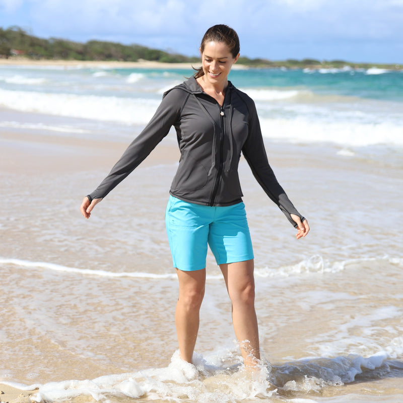 Woman Walking in the Ocean in UV Skinz's Women's Board Shorts in Aqua|aqua