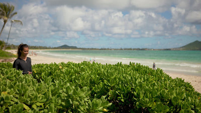 Woman walking to the beach in UV Skinz's women's long sleeve swimsuit with UPF in black