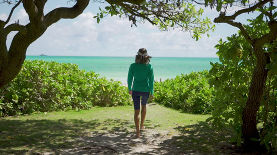 Woman walking to the ocean in UV Skinz's women's swim visor