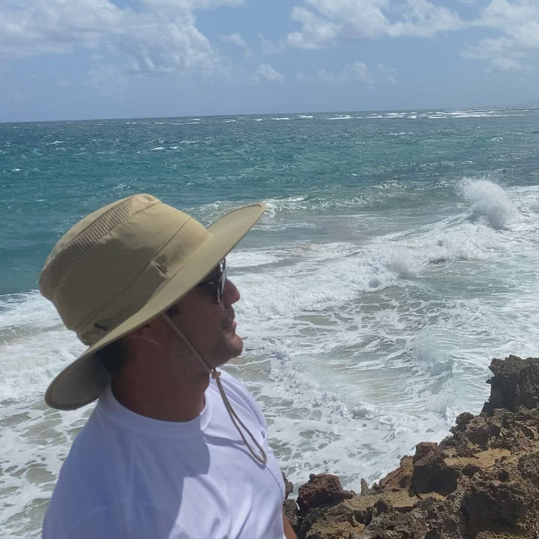 Man enjoying the beach in UV Skinz's wide brim sun hat