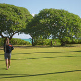 Woman walking on the beach in UV Skinz's long sleeve women's rash guard