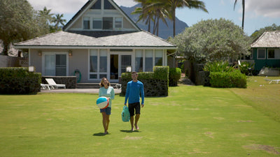 A Couple Playing on the Beach in Their UV Skinz's Swimwear, Including the Women's Travel Skort