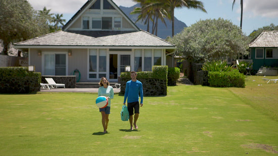 A Couple Playing on the Beach in Their UV Skinz's Swimwear, Including the Women's Travel Skort