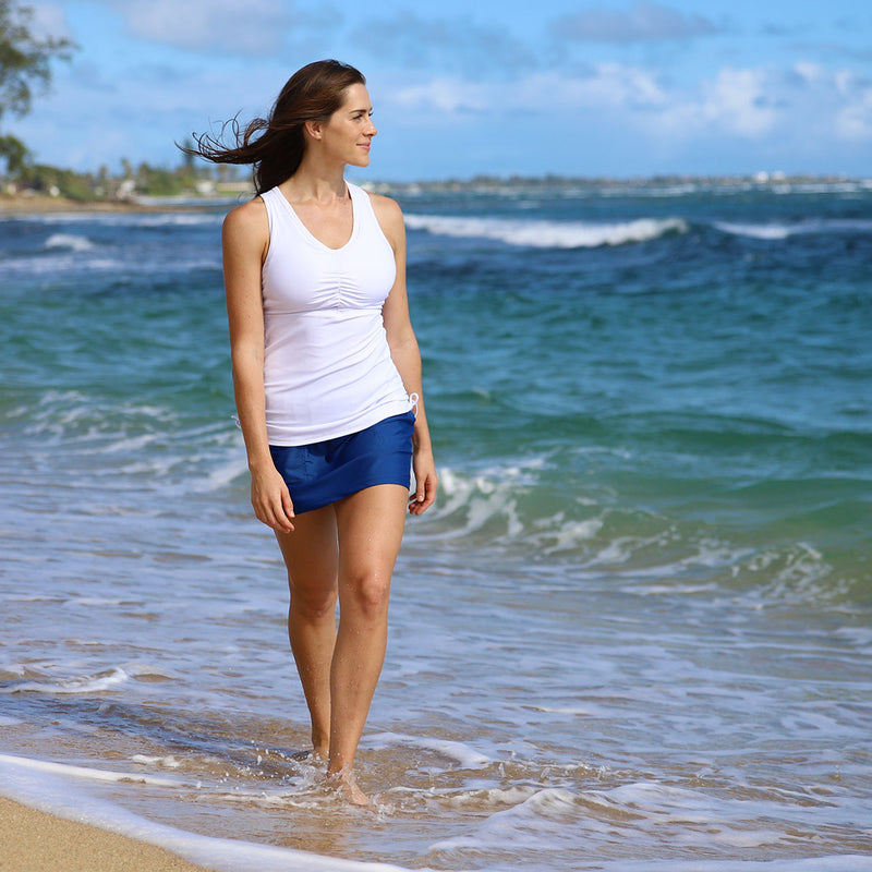 Woman walking in the ocean in our women's ruched swim tank top in white|white